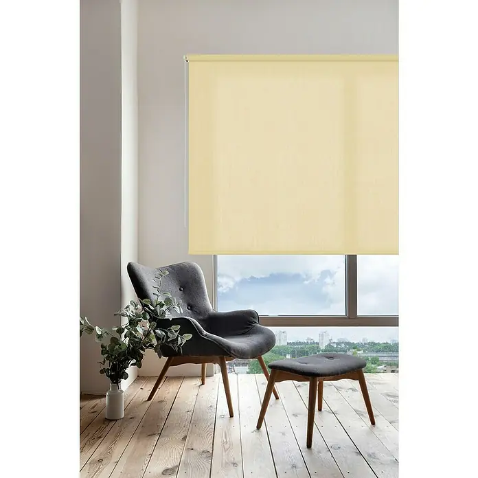 Estor enrollable Soft - An x Al: 100 x 250 cm, Vainilla - Interior elegante con un sillón cómodo y un estor beige suave que ofrece privacidad y luz tenue.