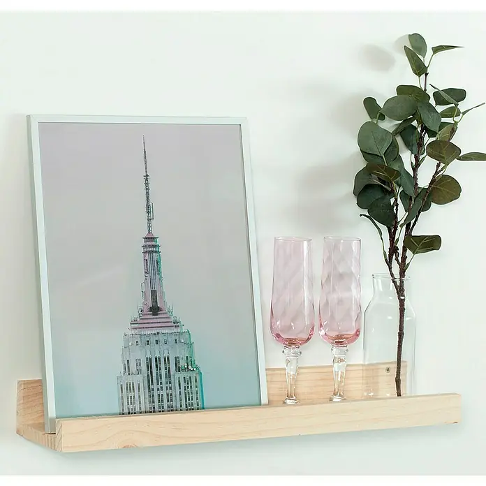 Astigarraga Estante para fotos - L x An x Al: 12,5 x 60 x 7 cm, Natural - Imagen de dos copas de champán rosas junto a un marco de fotos en una estantería de madera clara, complementadas con una rama de eucalipto en un jarrón de vidrio.