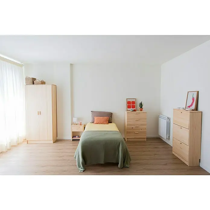 Astigarraga Vita Conjunto de muebles - Natural, 4 pzs. - Dormitorio luminoso con armario de madera clara, cómoda, mesita de noche y cama con manta verde, creando un ambiente acogedor.