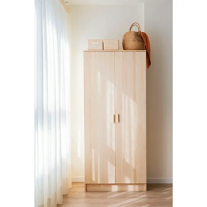 Astigarraga Vita Conjunto de muebles - Natural, 4 pzs. - Armario de color madera clara con dos cajas de madera y una cesta encima frente a una pared y una cortina.