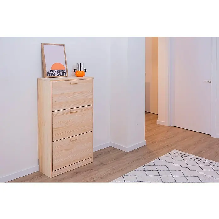 Astigarraga Vita Conjunto de muebles - Natural, 2 pzs. - Zapatero de madera con tres compartimentos. Decorado con una imagen y un jarrón, cerca de una puerta y una alfombra en el pasillo.