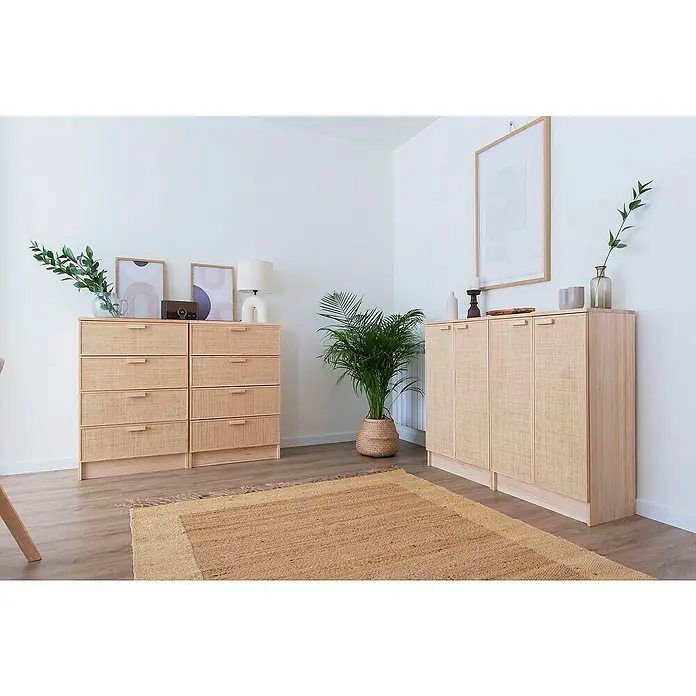 Astigarraga Aura Conjunto de muebles - 5 pzs., Madera maciza y rafia, Natural - Un salón luminoso que exhibe dos cómodas con cajones de mimbre y puertas de armario, complementado con una planta de interior y una alfombra.