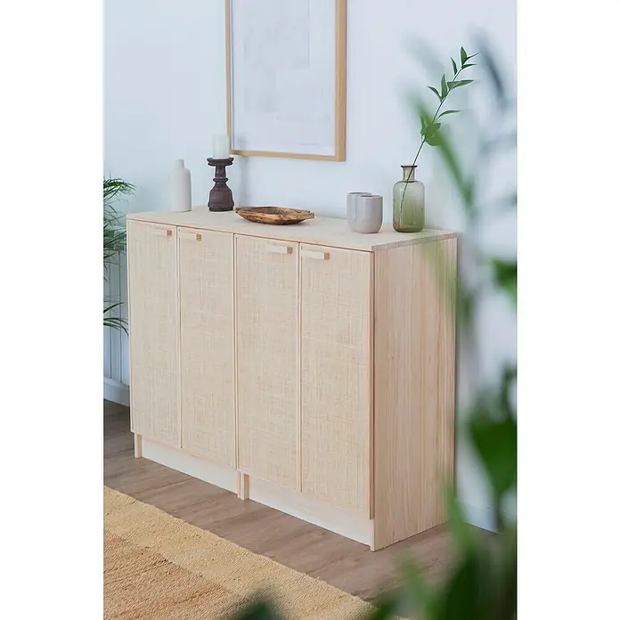 Astigarraga Aura Conjunto de muebles - 2 pzs., Madera maciza y rafia, Natural - Un armario de madera clara con cuatro puertas y tiradores cuadrados, decorado con jarrones, velas y un cuadro en la pared.