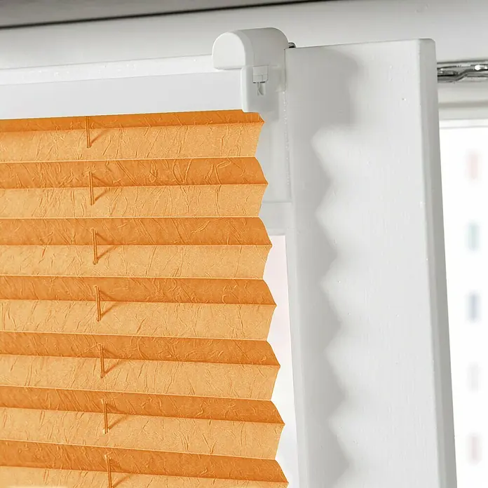 Expo Ambiente Plissee - B x H: 80 x 130 cm, Orange - Nahaufnahme einer orangefarbenen, plissierten Jalousie an einem Fenster, die ein warmes und einladendes Ambiente erzeugt.