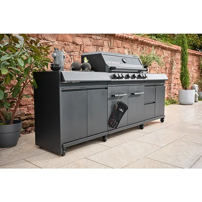 Kingstone Seitenblende - Stahl, Passend für: Kingstone Seitenschrank Cliff Big Basic links - Ein grauer Grill mit Unterschrank steht auf einer Terrasse vor einer Steinmauer. Handschuhe hängen an der Seite.