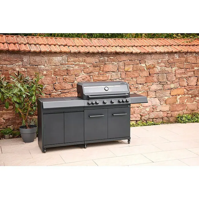 Kingstone Outdoorküchen-Modul Cliff Big Basic - Schwarz, B x T x H: 82 x 55,5 x 91 cm - Bild eines grauen Gasgrills mit Ablageflächen und Schränken im Freien, vor einer Backsteinmauer.