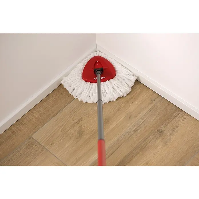 Vileda Set de limpieza Turbo smart - Otros, Rojo/Gris - Un primer plano de una mopa giratoria Vileda con cabezal rojo y mopa blanca, colocada en una esquina sobre un suelo de madera.