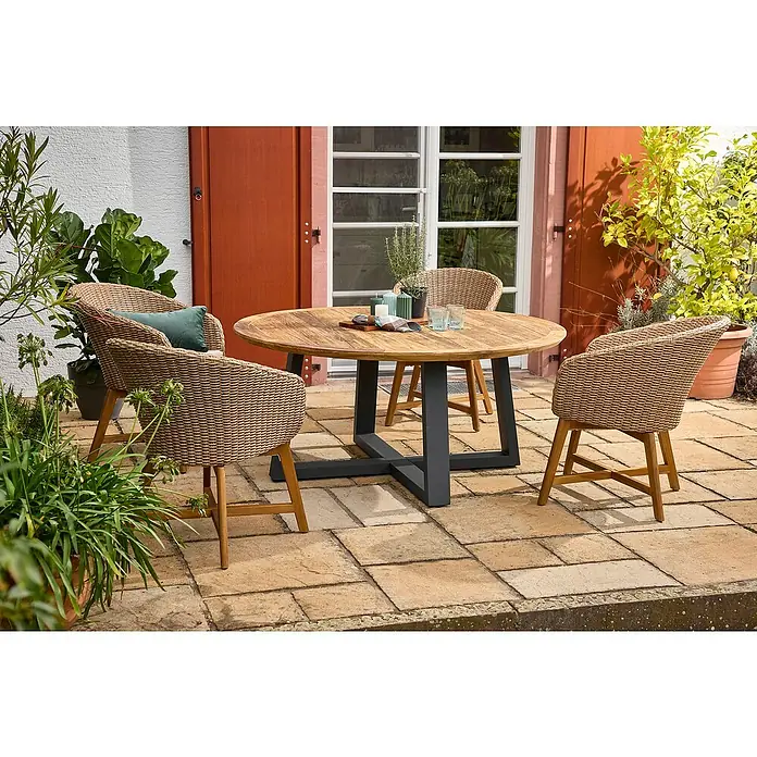Sunfun Pauline Gartenmöbel-Set - 6 -tlg., Teak, Aluminium, Akazie, Polyrattan, Hellbraun/Anthrazit - Gartenszene mit rundem Esstisch und Flechtstühlen auf einer gepflasterten Terrasse, umgeben von üppigem Grün.
