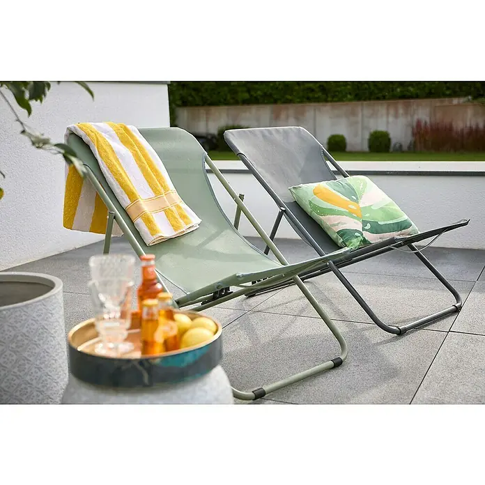 Sunfun Strandstuhl - B x T x H: 60 x 77 x 89 cm, Stahl, Textil, Urban Green - Zwei Liegestühle mit einem gelb gestreiften Handtuch und einem Kissen auf einer Terrasse.