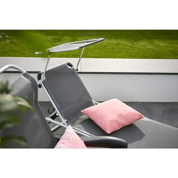 Madison Kissen Panama - 45 x 45 cm, Baumwoll-Polyester-Mischgewebe, Soft Pink - Ein grauer Liegestuhl mit einem Sonnendach und einem rosa Kissen darauf, ideal für entspannte Stunden im Freien.