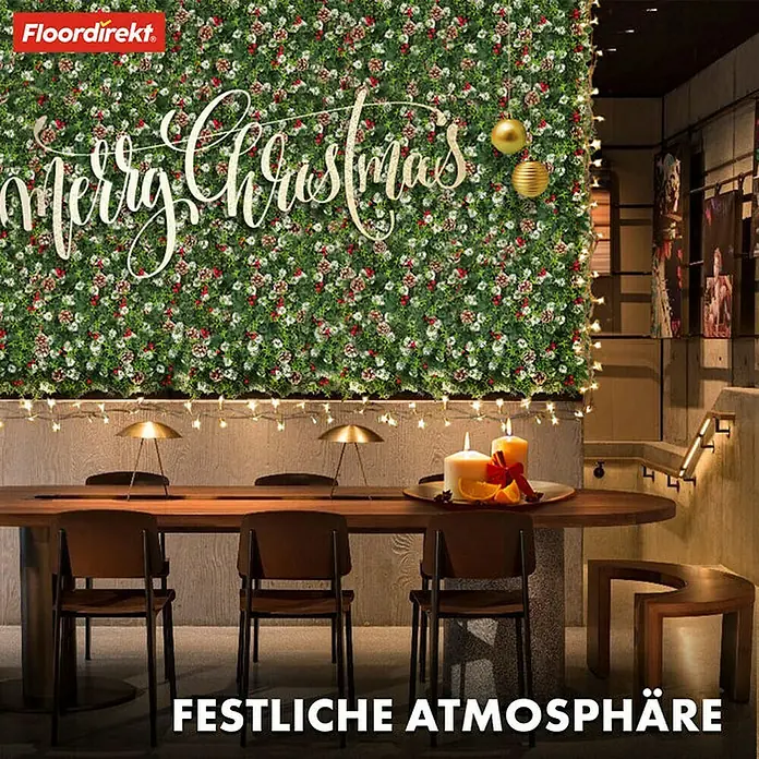 Floordirekt Kunstpflanze Pflanzenwand Festive 50 x 50 cm - Blütenfarbe: Grün, Kunststoff - Festliche Szene mit einem eleganten "Merry Christmas"-Schriftzug vor einer floralen Wand und dem FloorDirekt Logo.