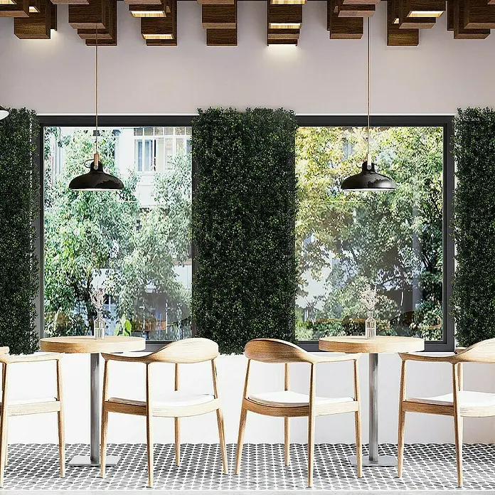 Floordirekt Kunstpflanze Pflanzenwand Buxus 50 x 50 cm - Blütenfarbe: Grün, Kunststoff - Elegante Café-Szene mit stilvollen Holzstühlen und sanfter Beleuchtung, die eine einladende Atmosphäre schafft.