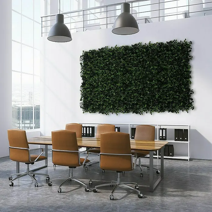 Floordirekt Kunstpflanze Pflanzenwand Buxus 50 x 50 cm - Blütenfarbe: Grün, Kunststoff - Ein Besprechungsraum mit einem großen Tisch und braunen Bürostühlen, beleuchtet von modernen Pendelleuchten. An der Wand befindet sich eine grüne Pflanzenwand.
