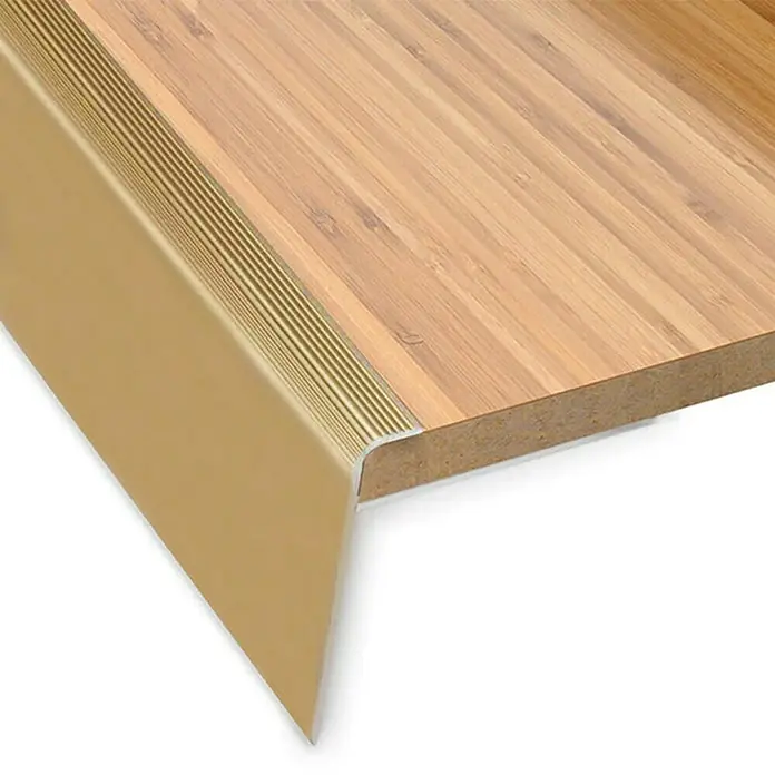 Floordirekt Treppenkantenprofil Safety 90 cm Gold - Aluminium, Gold, Eloxiert - Detailaufnahme einer Treppenkante aus Holz mit goldfarbenem Kantenschutzprofil für erhöhte Sicherheit und stilvolles Design.