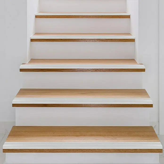 Floordirekt Treppenkantenprofil Glory 134 cm Silber - Aluminium, Silber, Eloxiert - Nahaufnahme einer Treppe mit hellen Holzstufen und weißen Setzstufen, die ein modernes und stilvolles Design aufweist.