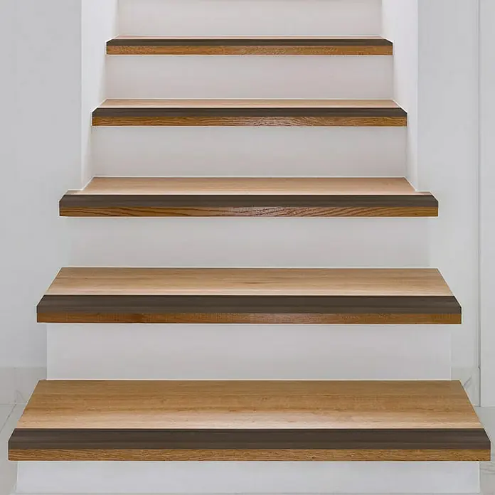 Floordirekt Treppenkantenprofil Glory 134 cm Bronze Dunkel - Aluminium, Bronze Hell, 134 x 1,7 cm, Eloxiert - Nahaufnahme einer Treppe mit Holzstufen und weißen Setzstufen, die ein modernes und stilvolles Designelement hervorheben.