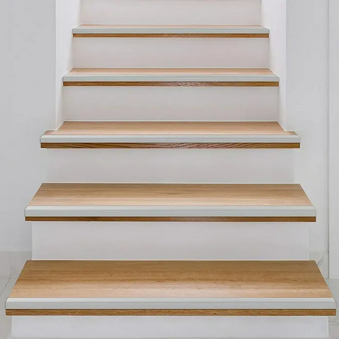Floordirekt Treppenkantenprofil Integral 100 x 3 x 3,5 cm Silber - Aluminium, Silber - Detailaufnahme einer Treppe mit Holzstufen und weißem Setzstufen, die ein sauberes und modernes Design zeigt. Ideal für Wohnräume.
