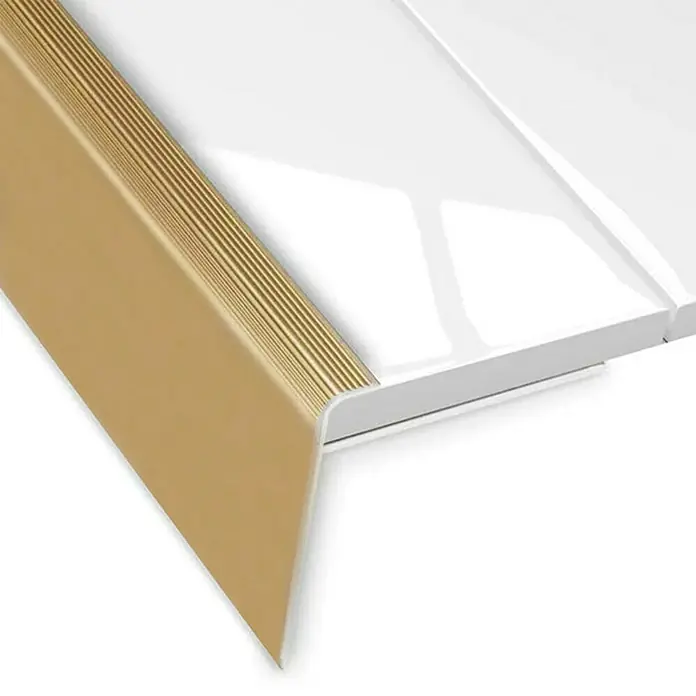 Floordirekt Treppenkantenprofil Safety 134 cm Gold - Aluminium, Gold, 134 x 5,3 cm, Eloxiert - Das Bild zeigt eine Treppenkantenprofil in Gold mit geriffelter Oberfläche und angrenzender weißer Oberfläche.