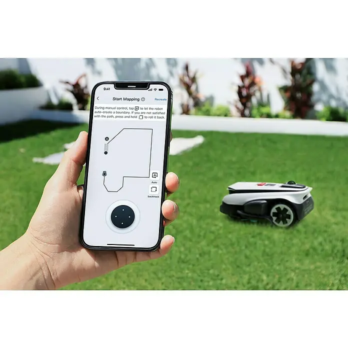 Ecovacs Goat Mähroboter A3000 LiDAR Pro - 3.000 m², Schnittbreite: 33 cm, Laser-gestützte Navigation, LiDAR - Ein Smartphone mit der App zur Steuerung eines Rasenmähroboters wird in der Hand gehalten, während der Roboter im Gras steht.