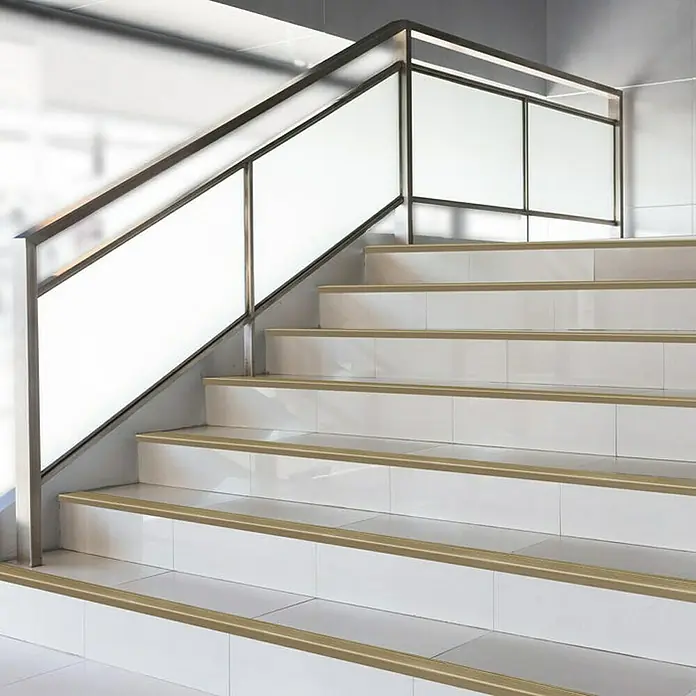 Floordirekt Treppenkantenprofil Safety 90 cm Bronze Dunkel - Aluminium, Bronze Hell, Eloxiert - Aufnahme von Treppenstufen mit goldfarbenen Treppenkantenprofilen, die für mehr Sicherheit und Stil sorgen.