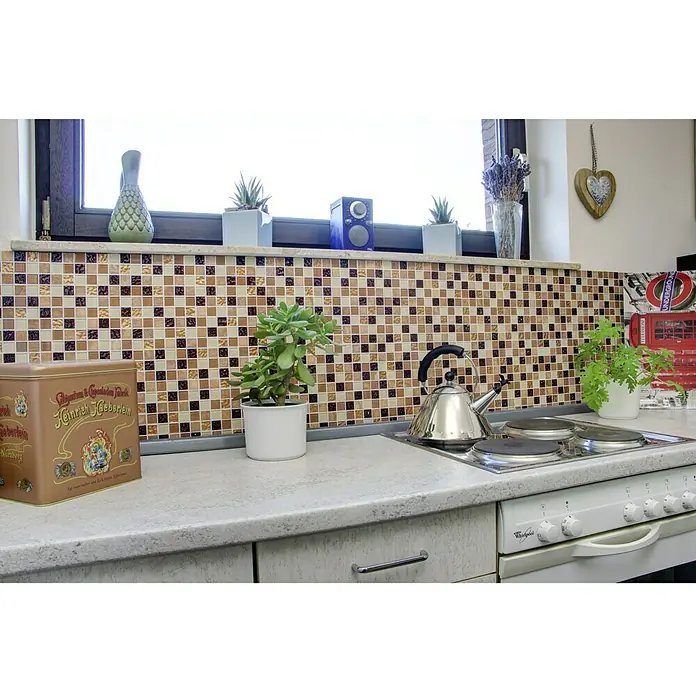 Selbstklebemosaik Quadrat Crystal Mix SAM 4M372 - 30 x 30 cm, Beige, Glänzend - Küchenstillleben mit Teedose, Wasserkocher und Pflanzen auf einer Arbeitsplatte vor Mosaikfliesen und einem Fenster.