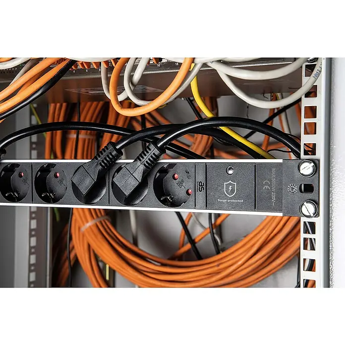as-schwabe Steckdosenleiste - 8-fach, Schwarz, Kabellänge: 2 m, IP20, Ohne Schalter - Nahaufnahme einer AS Schwabe Surge-geschützten Steckdosenleiste in einem Serverschrank mit eingesteckten Stromkabeln und verschiedenen Kabeln im Hintergrund.