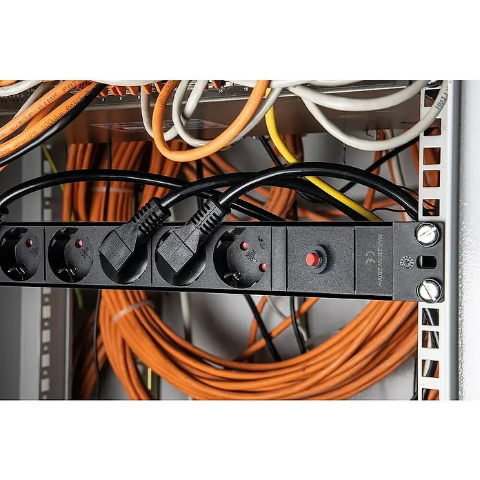 as-schwabe Steckdosenleiste - 8-fach, Schwarz, Kabellänge: 3 m, IP20, Ohne Schalter - Nahaufnahme einer Stromleiste in einem Serverschrank, mit eingesteckten Stromkabeln und diversen Datenkabeln im Hintergrund.