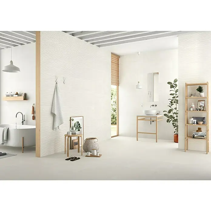 Revestimiento de pared Newlyn - 33,3 x 90 cm, Gris, Rectificado - Elegante baño con azulejos de pared texturizados blancos, una bañera exenta y una estantería de madera, ofreciendo un diseño moderno y minimalista.