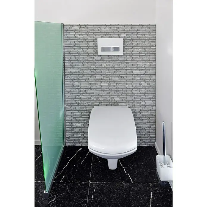 Mosaikfliese Verbund Crystal Mix XIC V1311 - 29,8 x 30,5 cm, Weiß, Glänzend - Nahaufnahme einer modernen Toilette mit glatter, weißer Oberfläche und einer strukturierten, grauen Ziegelwand im Hintergrund.