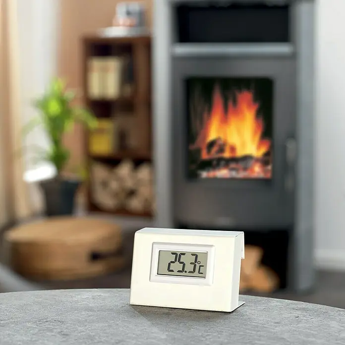 Justus Temperaturmessgerät - Metall - Digitales Thermometer im Wohnzimmer mit Kamin. Das Thermometer zeigt eine Temperatur von 25,3 Grad Celsius an.