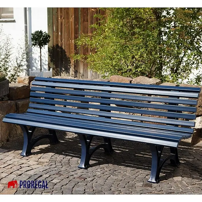 Proregal Gartenbank Jamaika 4-Sitzer aus Kunststoff - Blau - Blaue Parkbank mit Lattenrost und schwarzen Beinen vor Steinmauer. Ideal für den Garten oder öffentliche Plätze.