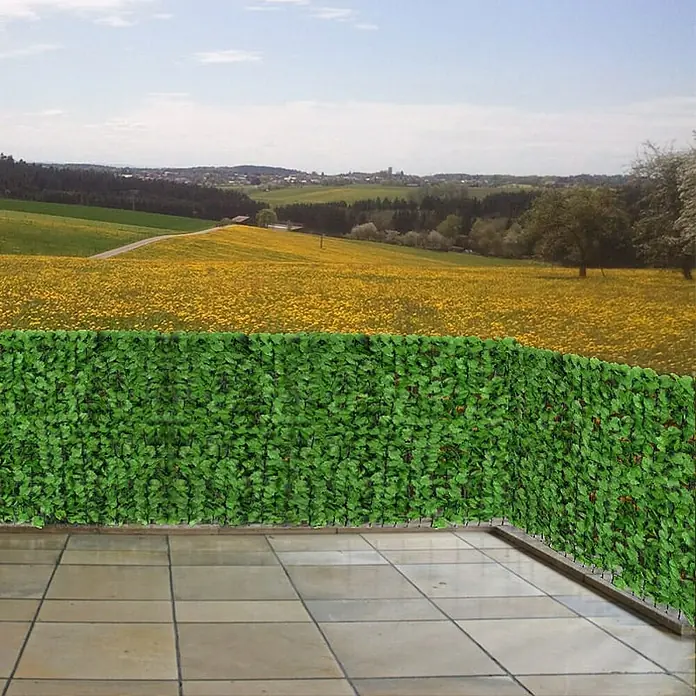 Proregal Sichtschutzelement Balkonsichtschutz - Kunststoff, Blatt hell - Diese Aufnahme zeigt eine dekorative grüne Sichtschutzwand aus Blättern auf einer Terrasse, die Privatsphäre schafft und gleichzeitig einen schönen Ausblick bietet.