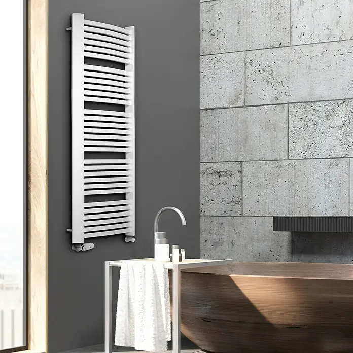 Camargue Badheizkörper Kastor - B x H: 580 x 1.600 mm, Wärmeleistung bei Vorlauftemperatur von 75 °C (D: 50): 1.103 W, Weiß - Weißer Handtuchwärmer an grauer Wand im Badezimmer neben Waschbecken und Badewanne.