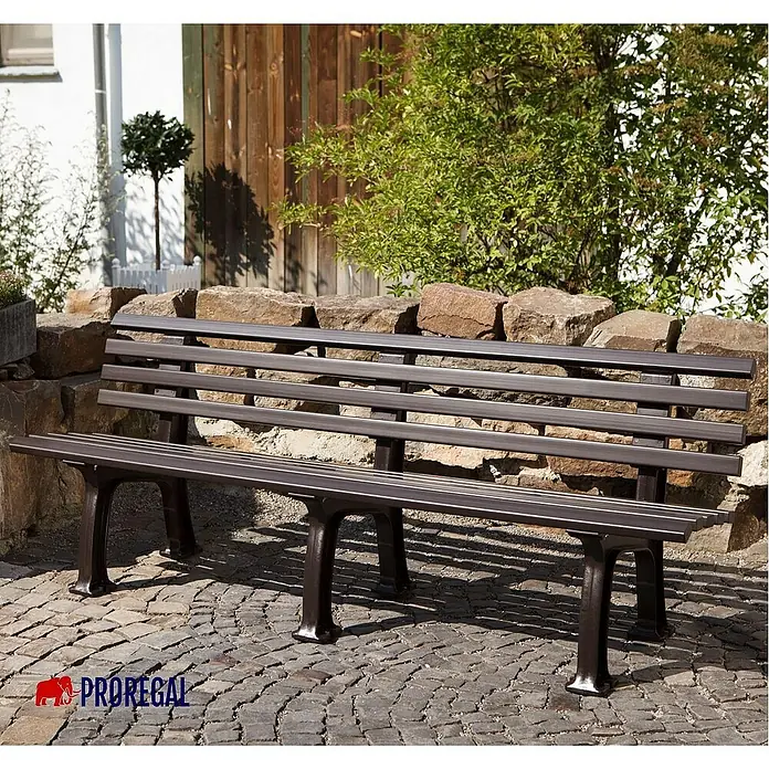 Proregal Gartenbank Antigua 4-Sitzer aus Kunststoff - Braun - Eine lange, braune Parkbank aus Metall mit Latten auf einem gepflasterten Platz, ideal zum Verweilen.