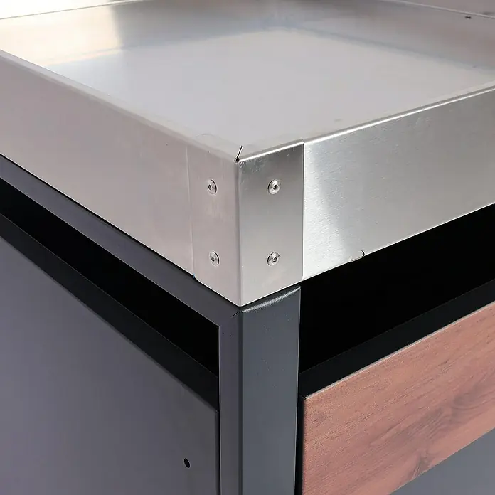 Proregal Mülltonnenbox 2er Mülltonnenverkleidung mit Pflanzkasten - 132 x 80 cm, Metall, Kirsche-Holzoptik Dunkelbraun, Geeignet für Anzahl Mülltonnen: 2 Stk. - Detailaufnahme einer Edelstahl-Arbeitsplatte mit robusten Metallverbindungen auf einer stilvollen Kücheninsel.