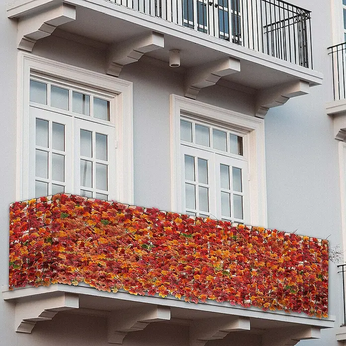 Proregal Sichtschutzelement Balkonsichtschutz - Kunststoff, Ahorn Rot-Gelb - Balkon mit künstlichem Efeu-Sichtschutz in Herbstfarben, der Privatsphäre und dekorative Elemente kombiniert.
