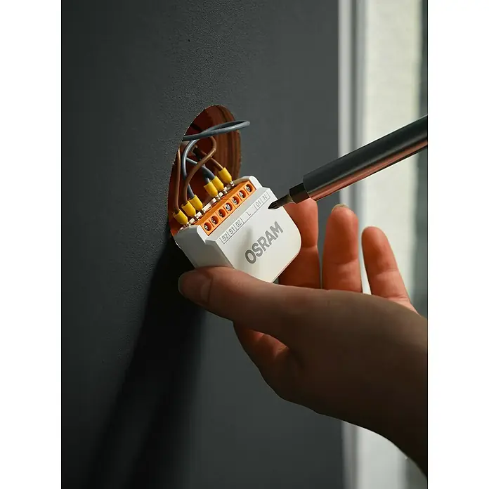 Osram Smart+ Schalter 2CH - Weiß, Innen - Ein Osram-Schaltmodul wird mit einem Schraubenzieher an der Wand befestigt.