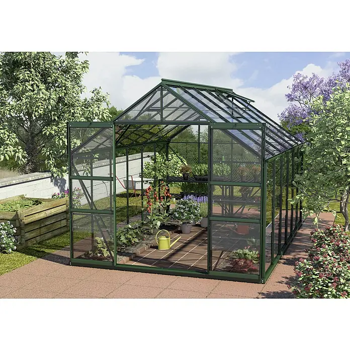 Vitavia Gewächshaus Mars 9900 - Außenmaß inkl. Dachüberstand (B x T): 257 x 383 cm, 3 mm, Smaragd - Ein grünes Gewächshaus mit Pflanzen, Tomaten und einem gelben Wasserkrug auf einem Ziegelboden im Garten.