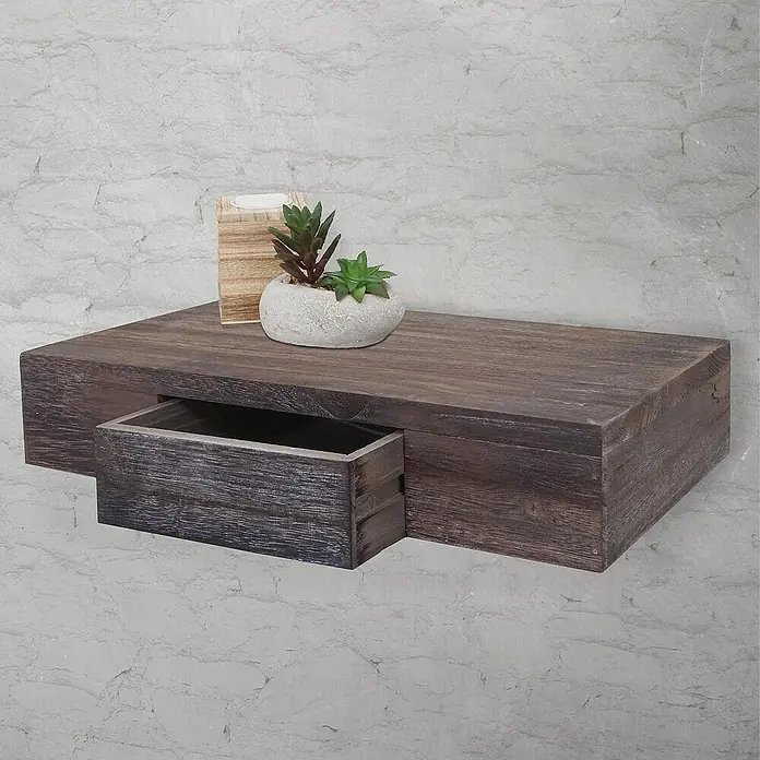 Berlinlodge Holzregal Wandregal Ilse - Anzahl Böden: 1 Stk., Einhängen, Braun - Wandregal mit Schublade aus dunklem Holz, dekoriert mit einer Pflanze und einem Kerzenhalter, vor einer weißen Backsteinmauer.
