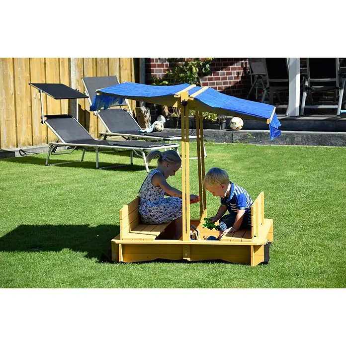 Dobar Sandkasten112 x 112 x 112 cm, Höhenverstellbares Dach - Ein gelber Sandkasten mit blauem Sonnenschutz, in dem zwei Kinder im Garten spielen. Gartenmöbel sind im Hintergrund zu sehen.