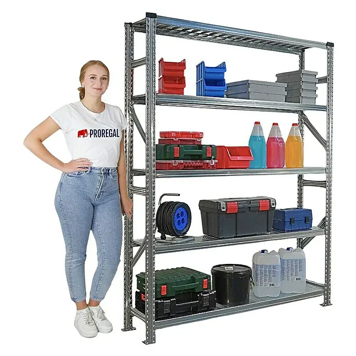 Proregal Metallregal Fachbodenregal PROXIMO Grundregal - Traglast pro Boden: 130 kg, Anzahl Böden: 5 Stk., Stecken, Verzinkt - Ein großes, silbernes Schwerlastregal mit fünf Ebenen, beladen mit Werkzeugkästen, Kanistern und Behältern. Eine Frau steht daneben.