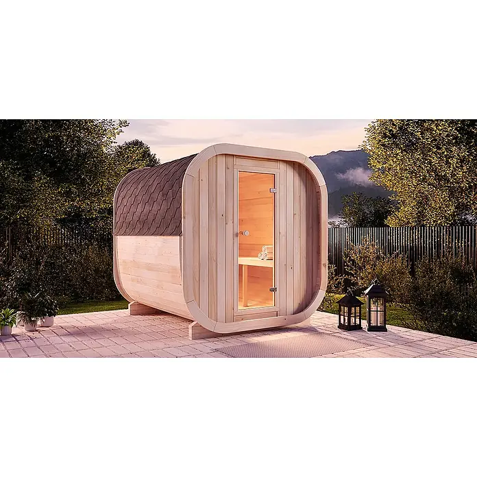 FinnTherm Fasssauna ScandiCube Comfort - Holz - Eine Fasssauna aus hellem Holz mit Glastür und Schindeldach steht auf einer Terrasse im Garten.
