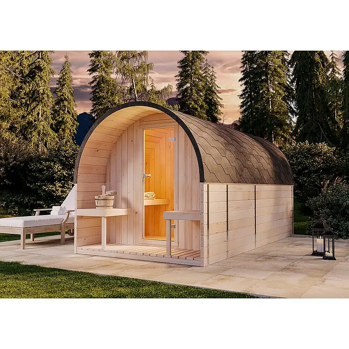 FinnTherm Fasssauna ScandiPod Deluxe - Holz - Ein Fass-Sauna im Freien mit Holzverkleidung und schwarzem Dach, umgeben von Grün und mit Liegestuhl. Für Entspannung pur!