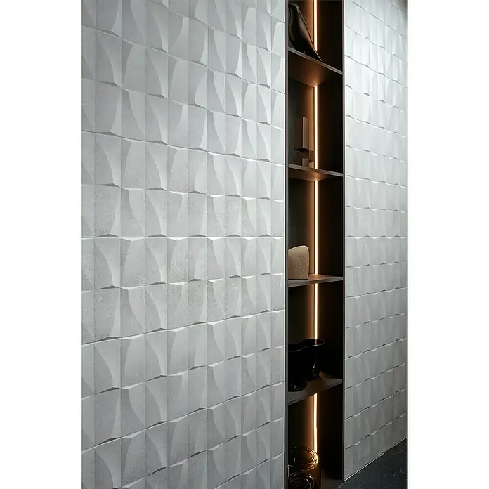 Revestimiento de pared Brikston Decor - 30 x 90 cm, Blanco, Rectificado, Relieve - Primer plano de una pared con paneles tridimensionales y una estantería empotrada con objetos decorativos.