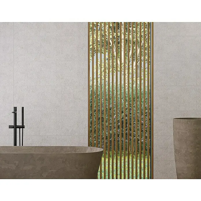 Revestimiento de pared Nomad - 30 x 90 cm, Lino, Rectificado - Elegante baño con bañera exenta y listones de madera verticales frente a una ventana con vistas a una exuberante vegetación.