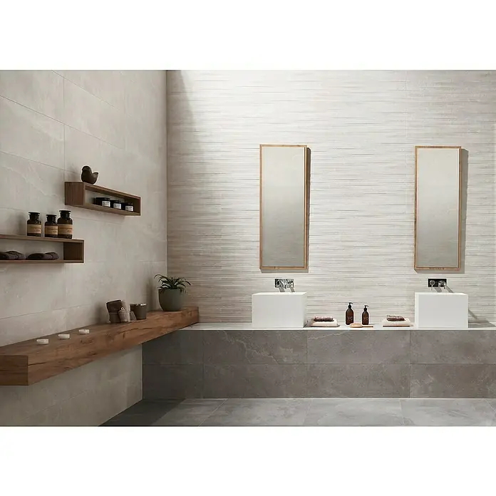 Revestimiento de pared Aurea Decor - 30 x 90 cm, Gris, Rectificado, Relieve - Diseño elegante de baño con dos lavabos sobre encimera, espejos rectangulares y elementos de madera que crean un ambiente cálido.