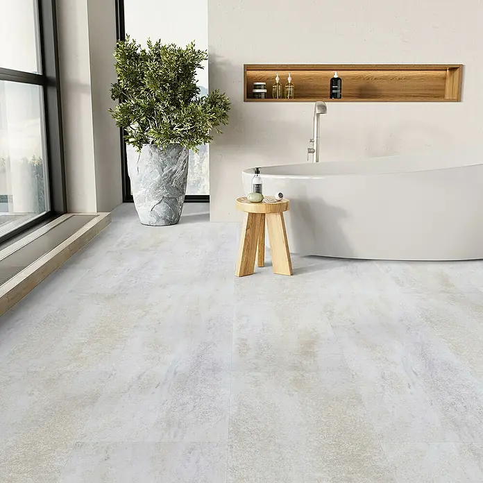 Parador Vinylboden Basic 5.3 - Dolomit weiß, Fliese, 914 x 457 x 5,3 mm - Ein modernes Badezimmer mit einem freistehenden Bad, einem Holzhocker und einem großen Fenster mit Blick auf die Natur.