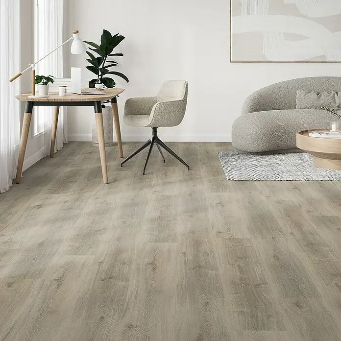 Parador Vinylboden Classic 2030 - Eiche Royal weiß gekälkt Gebürstete Struktur, Landhausdiele, 1.207 x 216 x 9,6 mm - Einladender Wohnraum mit hellen Holzböden, einem stilvollen Schreibtisch und einem bequemen Sessel, der eine moderne und gemütliche Atmosphäre schafft.