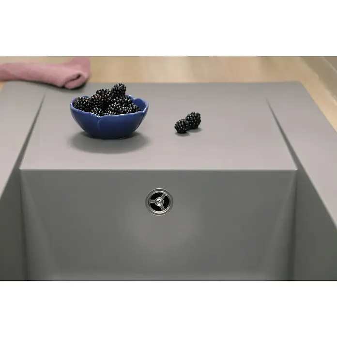 Respekta Einbauspüle Denver - 100 x 50 cm, Betongrau, Anzahl Becken: 1 Stk. - Nahaufnahme einer grauen Küchenspüle mit einem blauen Schälchen Brombeeren und einem rosa Tuch im Hintergrund.