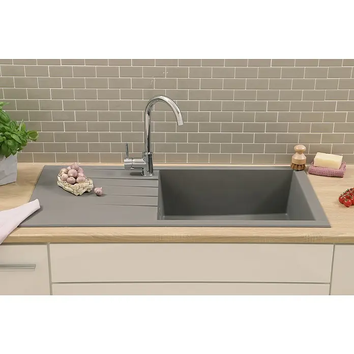 Respekta Einbauspüle Houston - 100 x 50 cm, Betongrau, Anzahl Becken: 1 Stk. - Eine moderne Küchenspüle aus grauem Stein mit Abtropffläche, Armatur und einigen Küchenutensilien auf einer hellen Arbeitsplatte.